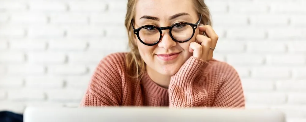 A very content lady sitting in front of a computer screen learning about keyword intent. 